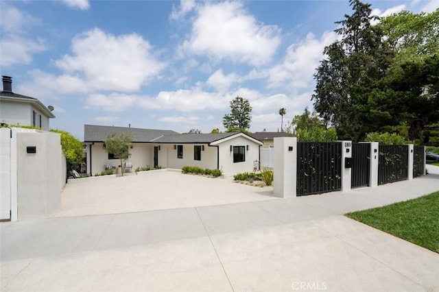 view of front facade featuring fence, a gate, and stucco siding