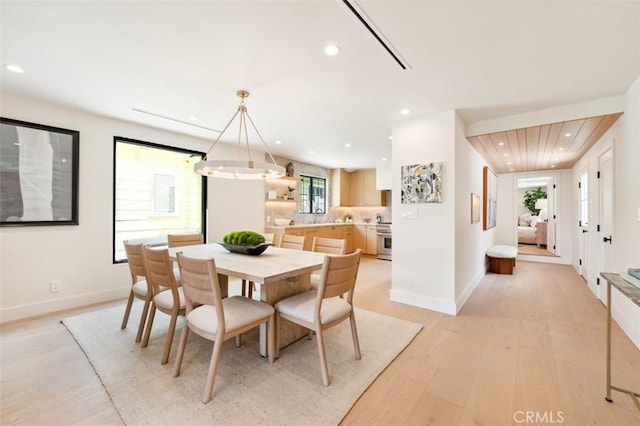 dining space featuring recessed lighting, light wood-style flooring, baseboards, and a notable chandelier