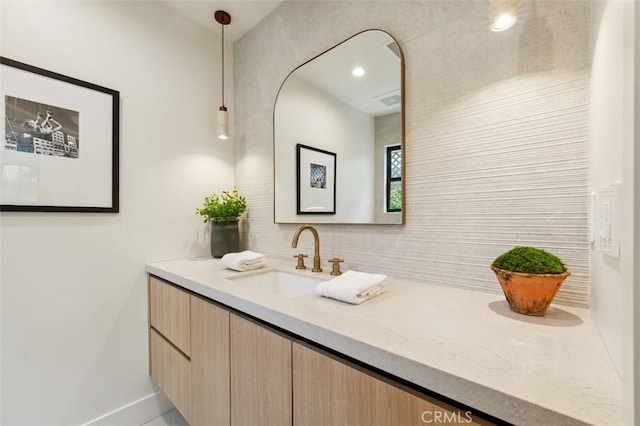 bathroom with vanity, baseboards, and tasteful backsplash
