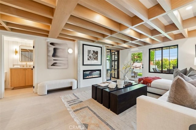 living room featuring a large fireplace, coffered ceiling, light wood finished floors, and beamed ceiling