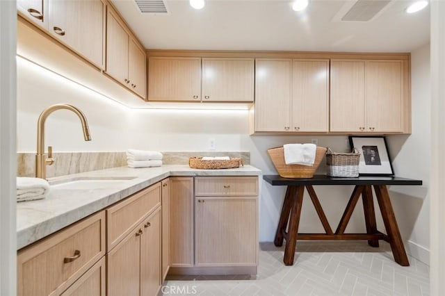 kitchen featuring a sink, light brown cabinets, and visible vents
