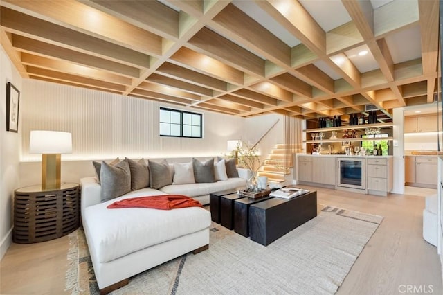 living room with a dry bar, light wood-style floors, beverage cooler, stairs, and coffered ceiling