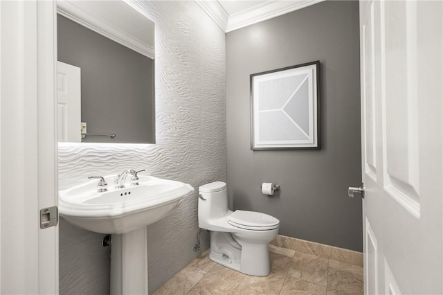 bathroom featuring toilet, baseboards, ornamental molding, and a sink