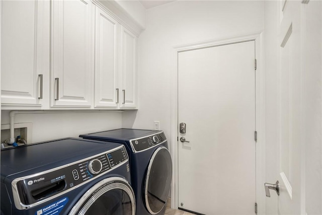 clothes washing area with washer and clothes dryer and cabinet space