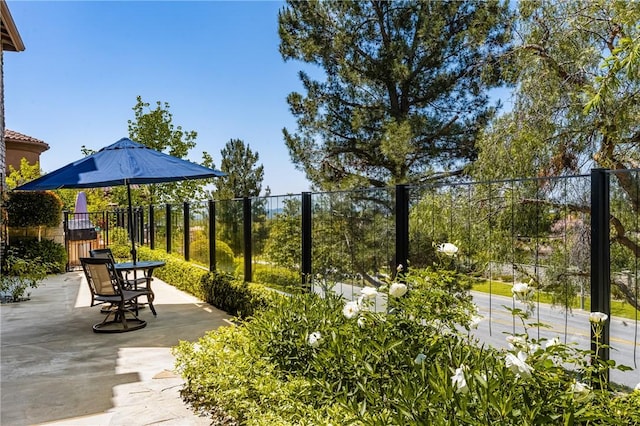 view of community with fence and a patio