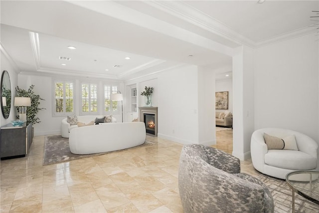 living room with crown molding, a tray ceiling, visible vents, and a glass covered fireplace