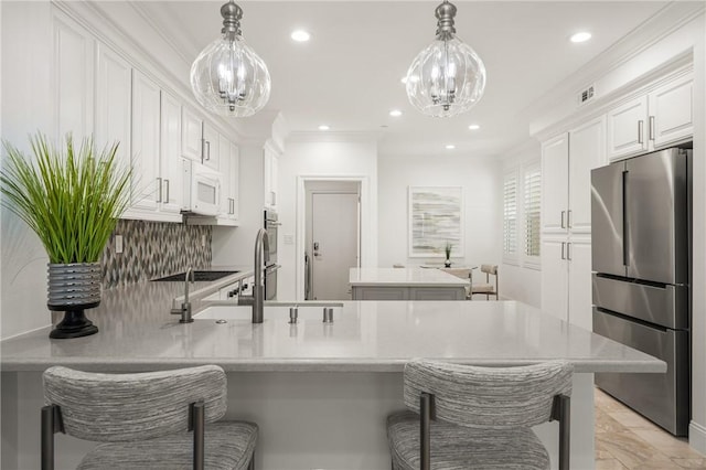 kitchen with light countertops, stainless steel appliances, an inviting chandelier, and a peninsula