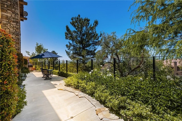 view of property's community featuring a patio, fence, and outdoor dining space