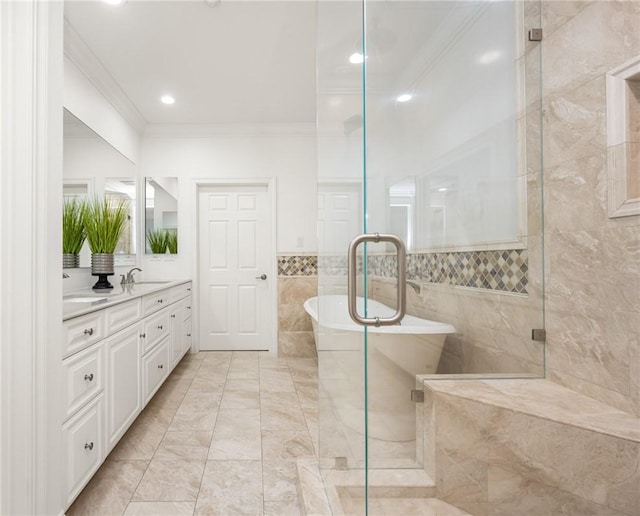 full bathroom featuring a sink, double vanity, ornamental molding, a soaking tub, and a stall shower