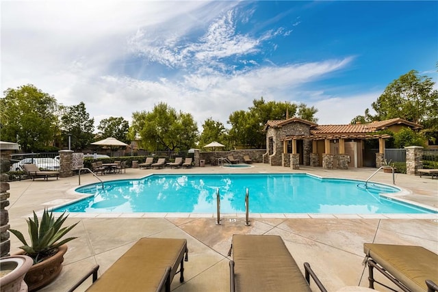 community pool featuring a patio and fence