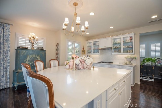 30223 Mahogany St, Murrieta, CA 92563 - kitchen with visible vents, dark wood finished floors, cooktop, a notable chandelier, and white cabinetry