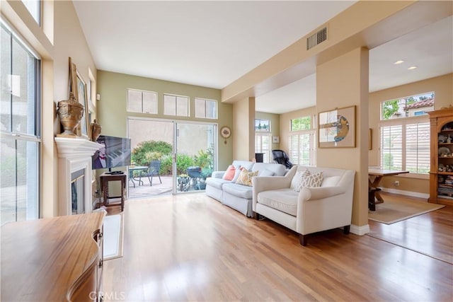 10925 Kimball Pl, Tustin, CA 92782 - living area with visible vents, a glass covered fireplace, plenty of natural light, and wood finished floors