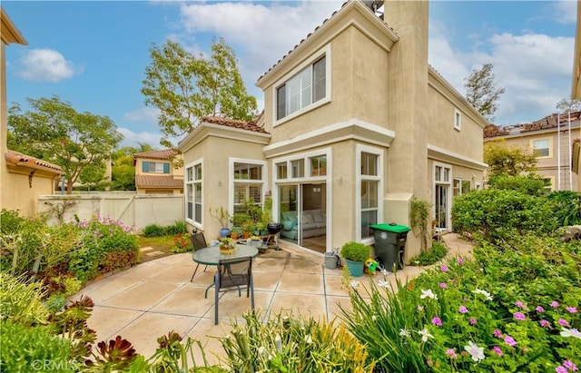 10925 Kimball Pl, Tustin, CA 92782 - rear view of house with a chimney, a tile roof, a patio area, fence, and stucco siding