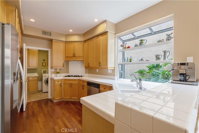 10925 Kimball Pl, Tustin, CA 92782 - kitchen featuring dark wood-style flooring, visible vents, appliances with stainless steel finishes, a sink, and washer / dryer