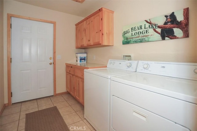 laundry room featuring washing machine and clothes dryer, baseboards, light tile patterned floors, and cabinet space