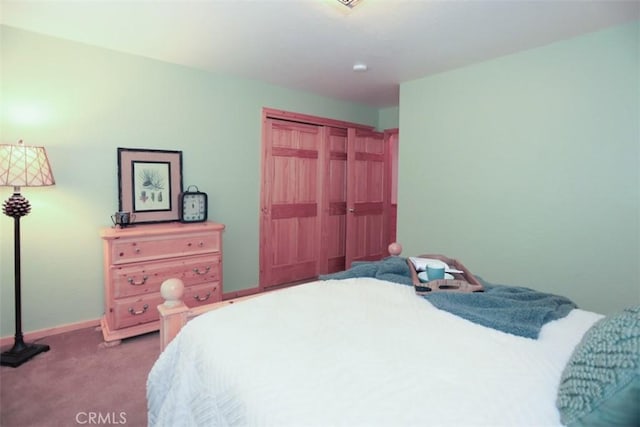 carpeted bedroom with baseboards and a closet