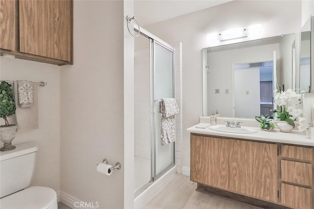 full bathroom with vanity, baseboards, toilet, and a shower stall