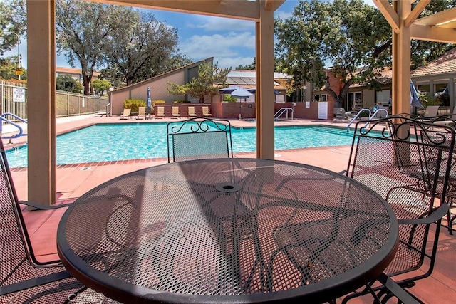 pool with a patio area and fence
