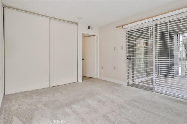unfurnished bedroom featuring visible vents, carpet flooring, and a closet