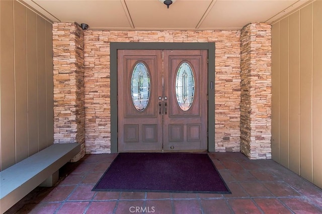 property entrance featuring french doors and stone siding