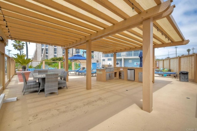 view of patio with fence, outdoor dining area, and a grill