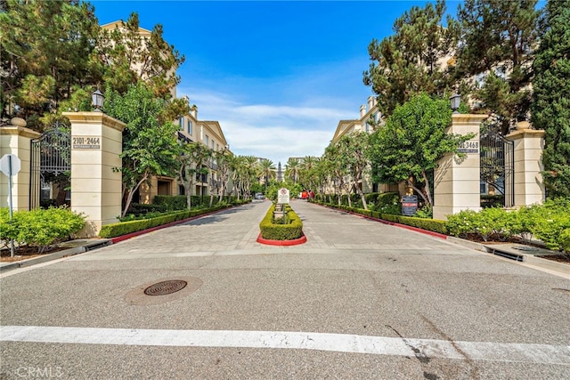view of asphalt road featuring curbs, street lighting, and a residential view
