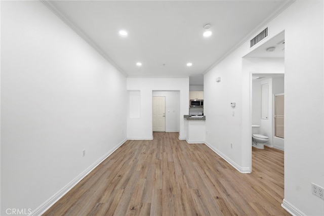 unfurnished living room with light wood finished floors, ornamental molding, baseboards, and recessed lighting