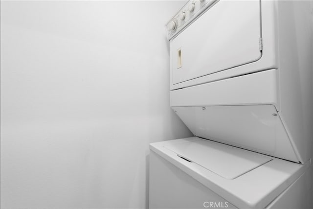 clothes washing area with estacked washer and dryer