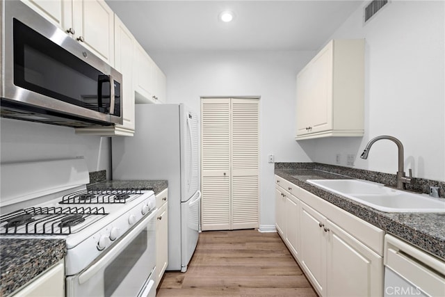 3131 Watermarke Pl, Irvine, CA 92612 - kitchen featuring white appliances, a sink, light wood-style floors, white cabinetry, and recessed lighting