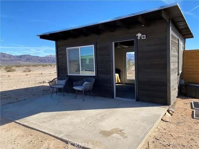 rear view of property with a patio area and a mountain view