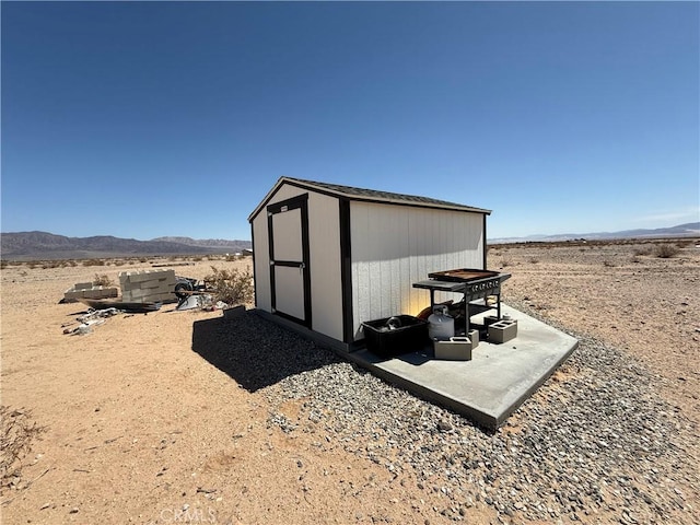 view of shed featuring a desert view and a mountain view