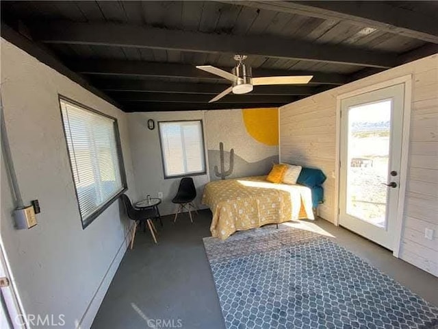 bedroom featuring wood walls, multiple windows, and beam ceiling
