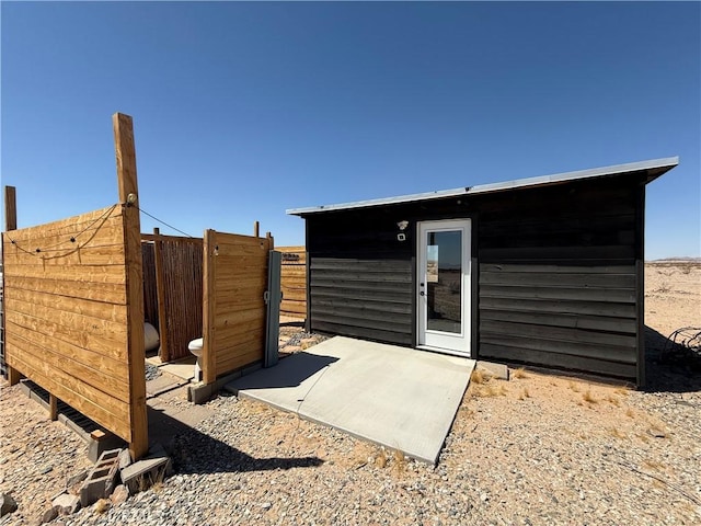 view of outbuilding featuring fence