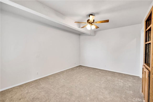 carpeted empty room with ceiling fan and baseboards