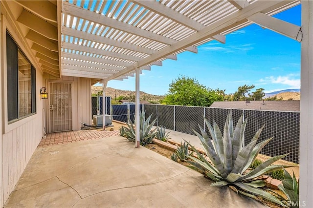 view of patio / terrace featuring a fenced backyard, a mountain view, and a pergola