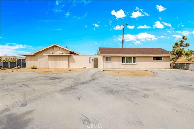 ranch-style house featuring fence