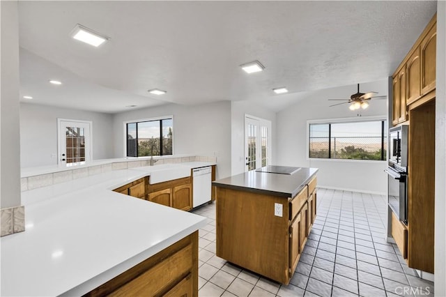 kitchen featuring a kitchen island, a wealth of natural light, a sink, and black appliances