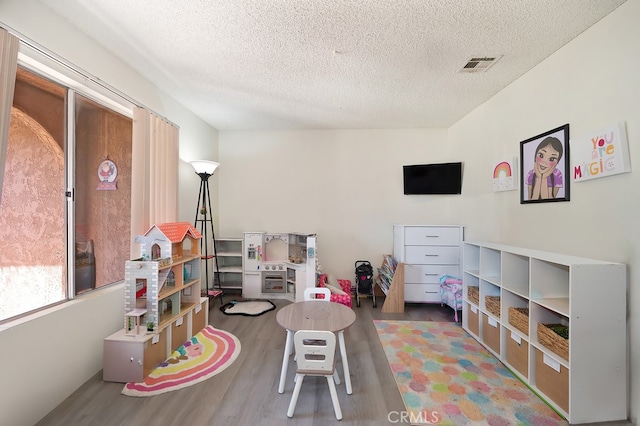 1107 B St, Brawley, CA 92227 - playroom featuring a textured ceiling, visible vents, and wood finished floors