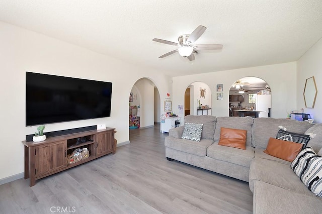1107 B St, Brawley, CA 92227 - living area featuring light wood-type flooring, arched walkways, baseboards, and ceiling fan