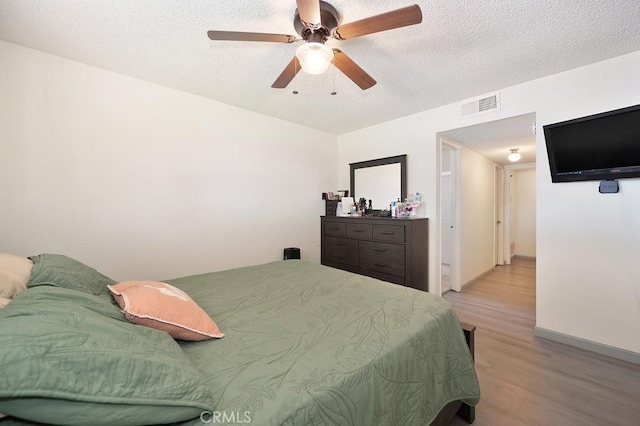 1107 B St, Brawley, CA 92227 - bedroom featuring ceiling fan, a textured ceiling, visible vents, baseboards, and light wood finished floors