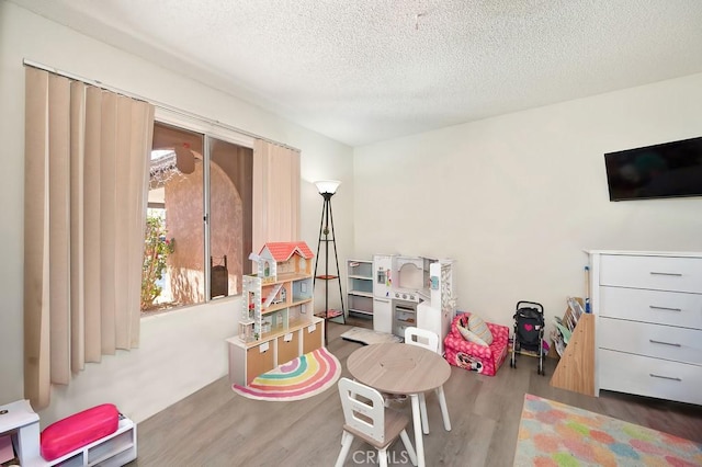 1107 B St, Brawley, CA 92227 - playroom featuring a textured ceiling and wood finished floors