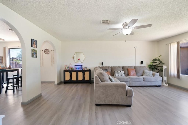 1107 B St, Brawley, CA 92227 - living area with light wood finished floors, arched walkways, a textured ceiling, a ceiling fan, and visible vents