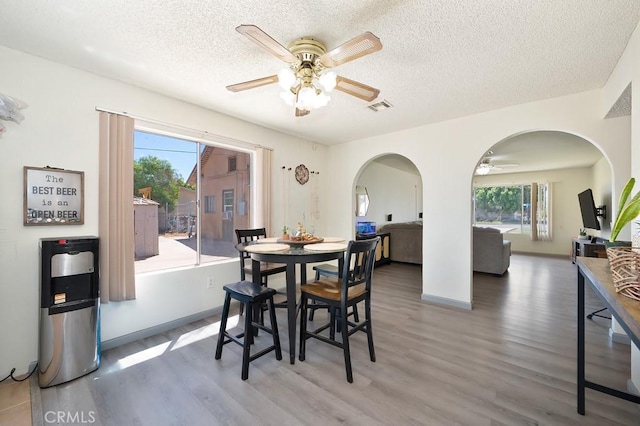 1107 B St, Brawley, CA 92227 - dining area with ceiling fan, a textured ceiling, visible vents, arched walkways, and wood finished floors