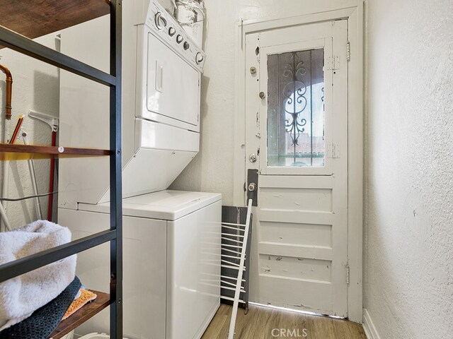 1407 Obispo Ave, Long Beach, CA 90804 - laundry area with stacked washer / dryer, a textured wall, light wood finished floors, and baseboards