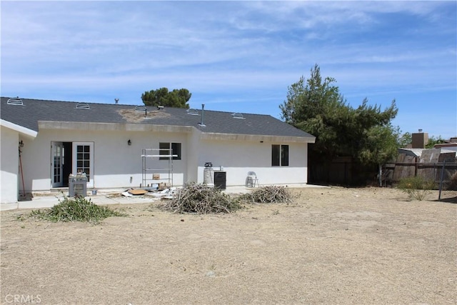 back of house featuring fence and stucco siding