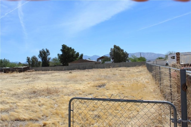 view of yard featuring fence and a mountain view
