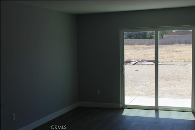 unfurnished room featuring dark wood-type flooring and baseboards