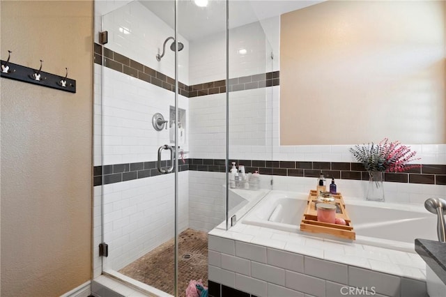 bathroom with a stall shower and a bath