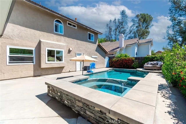 view of swimming pool featuring a patio area, fence, and a pool with connected hot tub