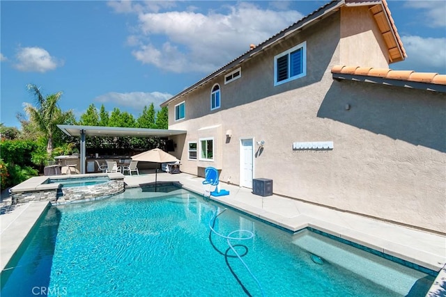 view of pool with a patio area and a pool with connected hot tub